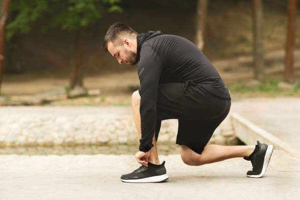 istock Male athlete tying running shoes lases getting ready for run 1172152126