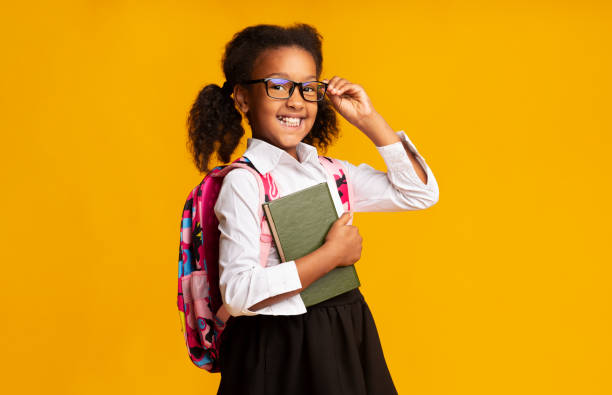 istock Elementary Student Girl Holding Books Smiling At Camera In Studio 1172152270