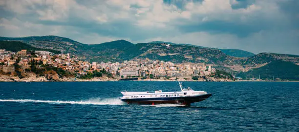 Kavala cityscape with cruise ship and hydrofoils boat skims across water