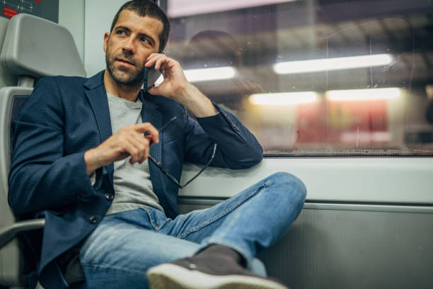 istock Gentleman riding in subway train and talking on mobile 1172154503