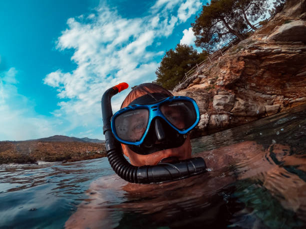 istock Man with blue snorkeling mask floating on the water 1172155006