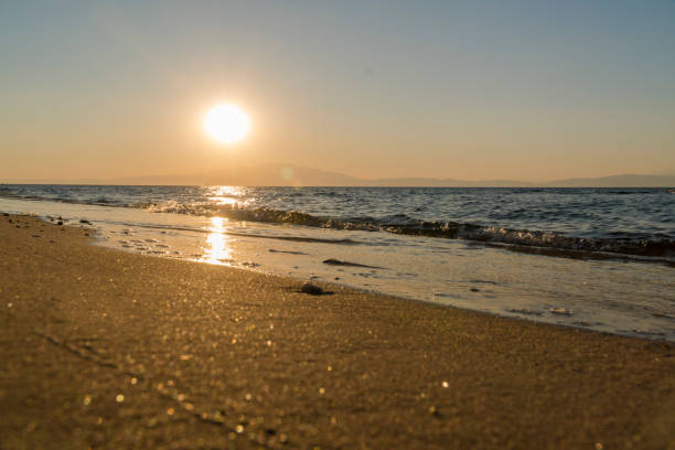 Low angle shot of empty beach at sunset.