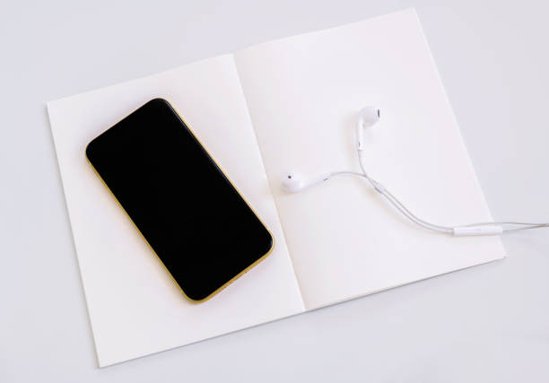istock Mobile phone and headphone on white empty page 1172157050