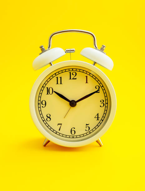 istock White clock on yellow background, 10 minutes after 10. Cheerful morning concept. 1172160964