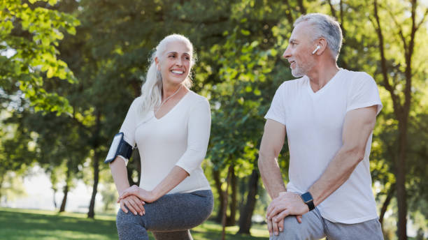 야외공원에서 서서 서로를 바라보며 워밍업 연습을 하는 활동적인 미소 선배 부부 - men gray hair vitality healthy lifestyle 뉴스 사진 이미지