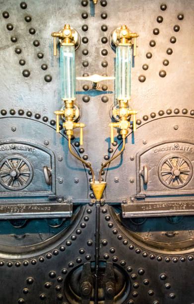 Engine Boiler August 21, 2019 – Tower Bridge, London, United Kingdom. A large and old type engine boiler faceplate, with 2 doors for where coal is put into. Faceplate stock pictures, royalty-free photos & images