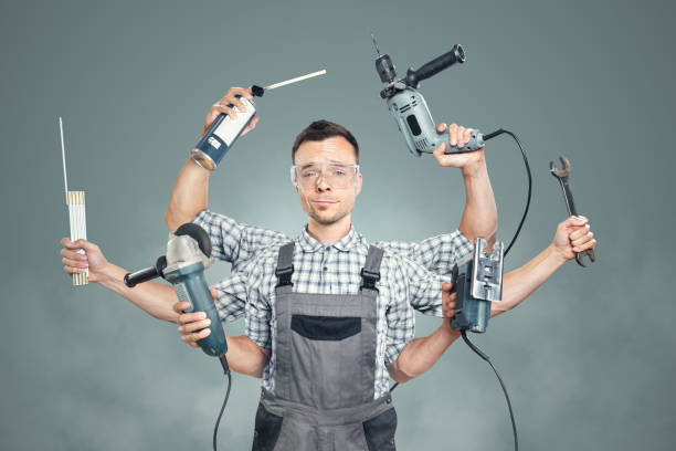 Funny portrait of a craftsman with 6 arms Photo montage of an artisan holding six different tools in his six arms. Isolated on a neutral background. Funny competent expression. custodian stock pictures, royalty-free photos & images