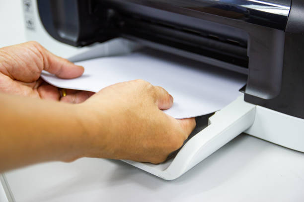 istock hand man lay down the paper from printer in the office 1172164504