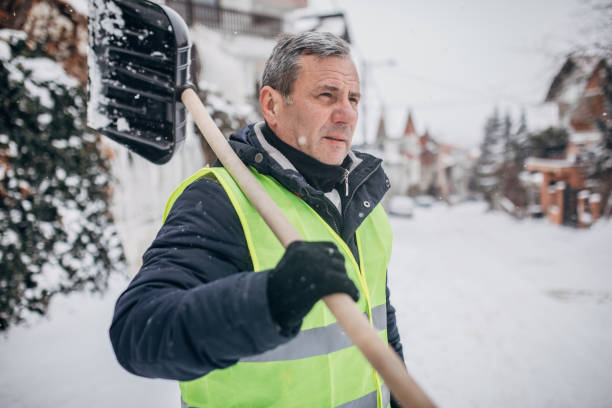 senior mann geht, um schnee zu reinigen - winterdienst stock-fotos und bilder