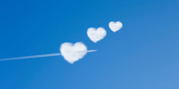 istock Airplane flies through a heart shaped cloud 1172169382