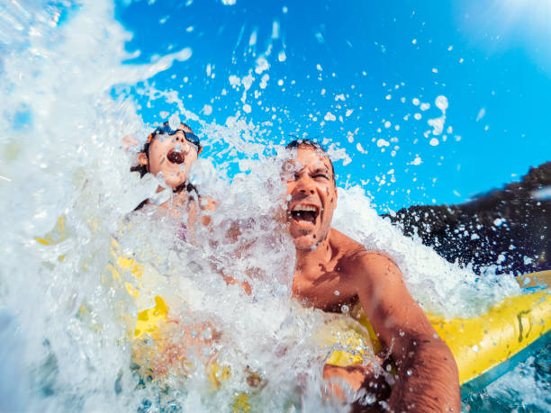 istock Family enjoying on the beach and getting splashed by the big wave 1172171574