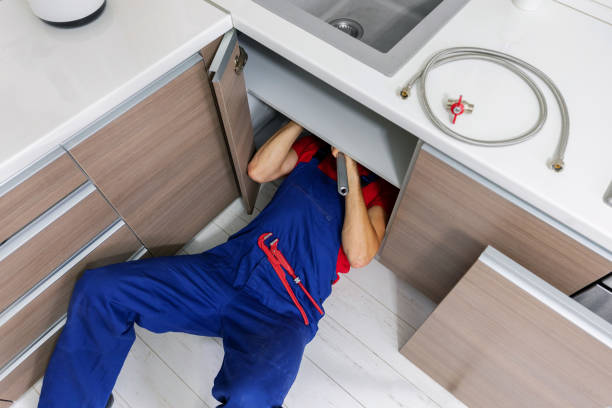 istock plumber working under domestic kitchen sink, repairing water pipes 1172174134