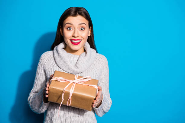 istock Portrait of astonished lady holding package wearing gray pullover isolated over blue background 1172176738