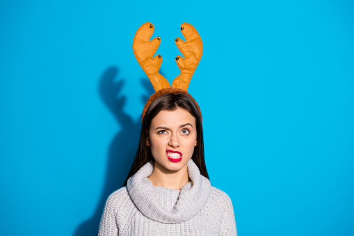 Photo of pretty lady dislike wearing toy horns knitted pullover isolated blue background