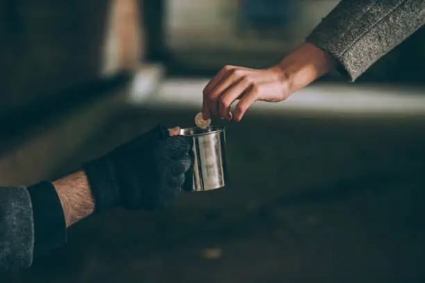 One man, young homeless on the street begging, woman handing him some money, part of