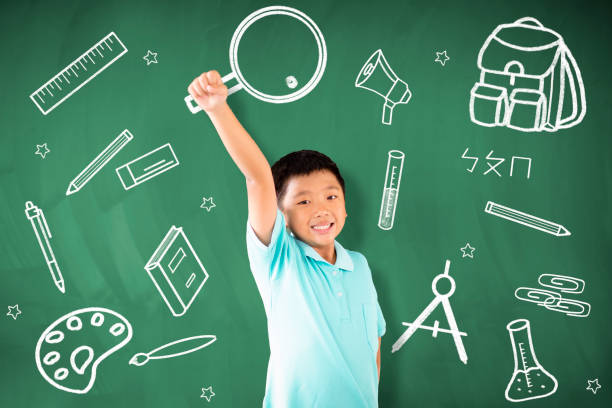 istock happy asian boy standing against chalkboard and education  concept 1172177374
