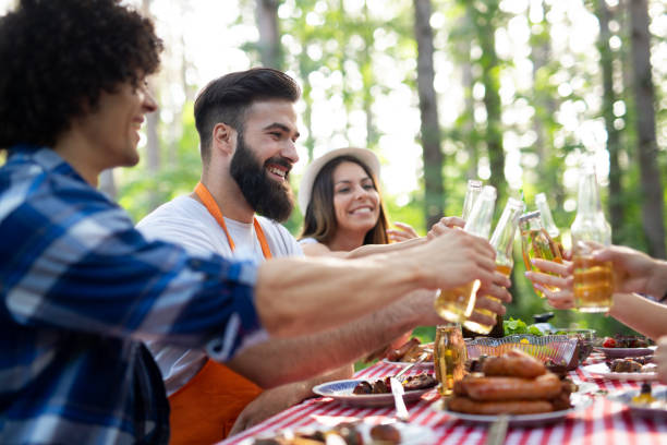 istock Friends making barbecue and having lunch in the nature 1172178123