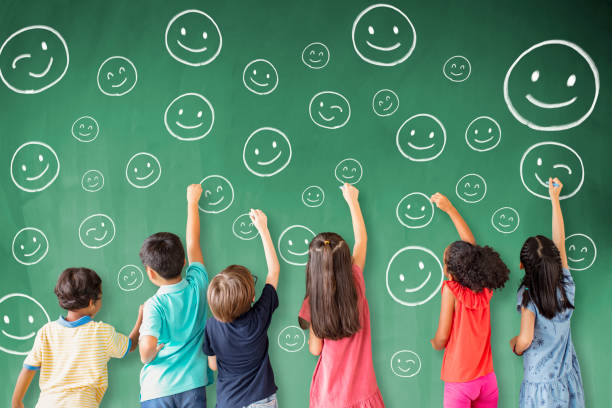 school children drawing emotion face icon on the chalkboard