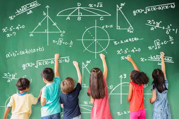 Photo of school children drawing math icon on the chalkboard