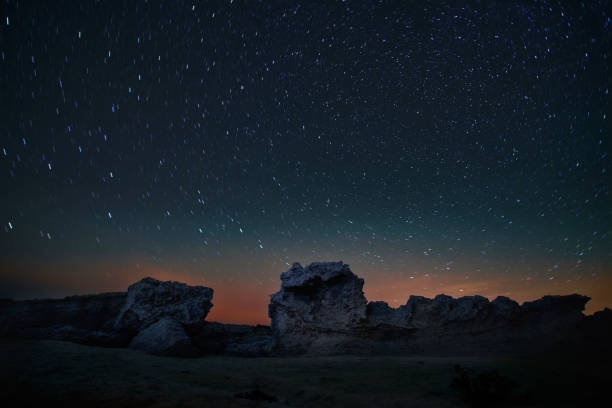 istock Night landscape with stars trails moving around one point 1172179435