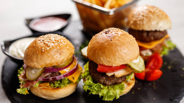 istock Three delicious mini burgers on a granite board 1172179544