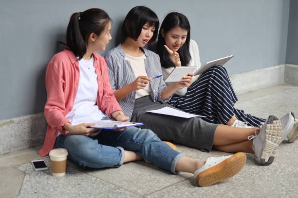 istock Young woman students discussing at corridor 1172183062