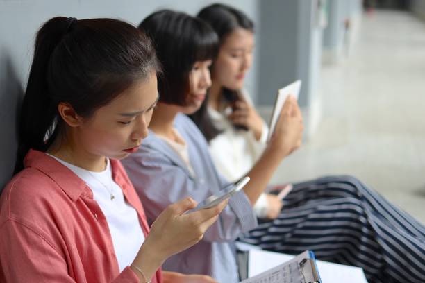istock Young woman students checking mobile tablet at corridor 1172183364