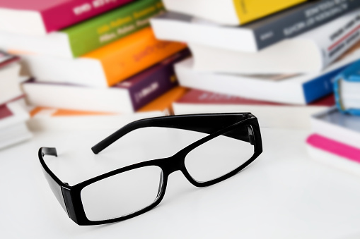Glasses and books against a white background