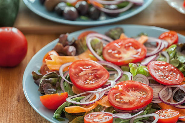 Grilled rump steak salad with fresh vegetables preparing process, raw vegetables at plate, close-up, no people, can be served separately as vegan or vegetarian side dish