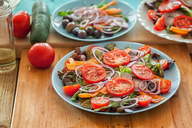 Grilled rump steak salad with fresh vegetables preparing process, raw vegetables at plate, close-up, no people, can be served separately as vegan or vegetarian side dish