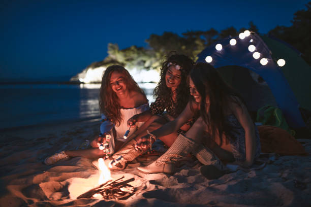 istock Women Roasting Marshmallows on Campfire by the sea 1172186200