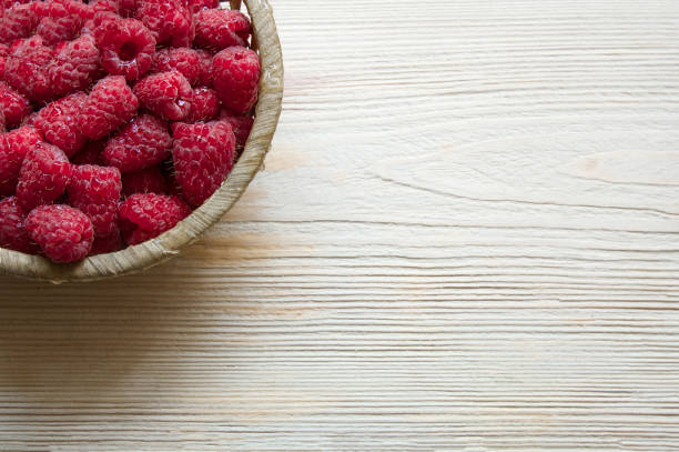 istock raspberries in a basket on a light wooden background 1172188116