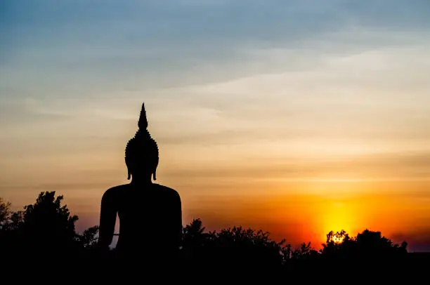 Photo of Silhouette photography of Buddha image monument in sunset sky.