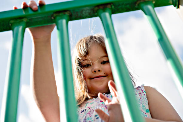 un portrait de trisomie 21 enfant fille à l'extérieur ayant l'amusement sur un stationnement - child cheerful little girls down syndrome photos et images de collection