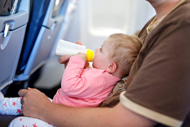 istock Father holding his baby daughter during flight on airplane going on vacations 1172193812