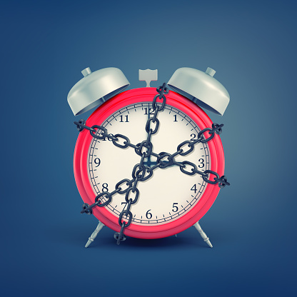 A 3D rendering of an old-fashioned alarm clock enchained in shackles on blue background.