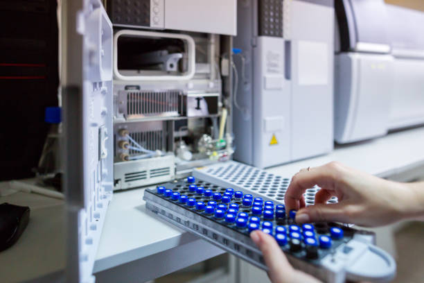 el científico del laboratorio prepara muestras para su descarga en el espectrodecrodetógrafo de cromatógrafo líquido de alto rendimiento. - hplc fotografías e imágenes de stock