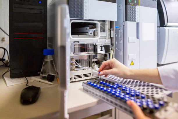 el científico del laboratorio prepara muestras para su descarga en el espectrodecrodetógrafo de cromatógrafo líquido de alto rendimiento. - hplc fotografías e imágenes de stock