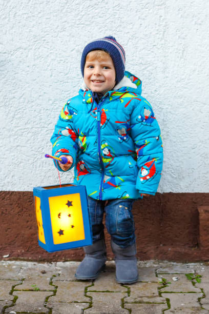 istock Little kid boy holding selfmade lanterns for a Halloween or St. Martin procession. Beautiful healthy cute child happy about children and family parade in kindergarten. German tradition Martinsumzug 1172201405