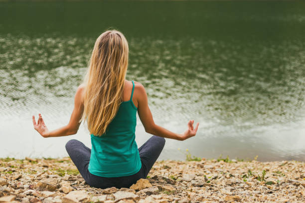 istock Woman meditating by the lake 1172203927