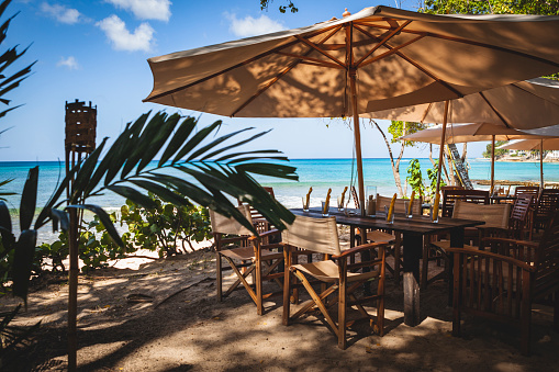 A long table and sun shade setup for seaside dining with a view out to the Caribbean Sea