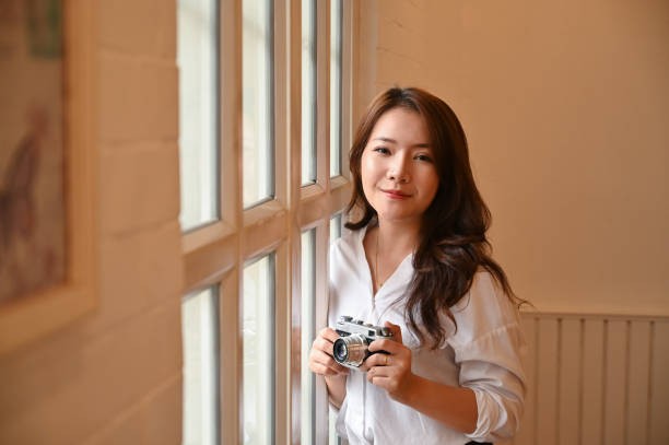 istock Female's hands holding retro vintage camera and looking at the camera. 1172207007