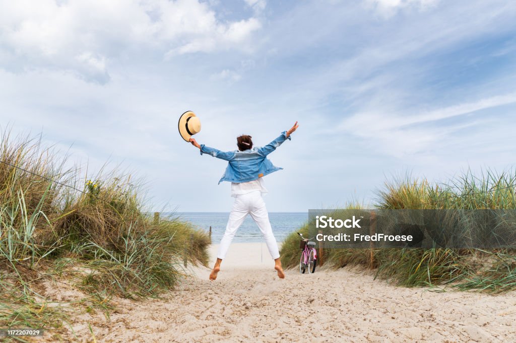 Happy woman with straw hut on beach Beach Stock Photo