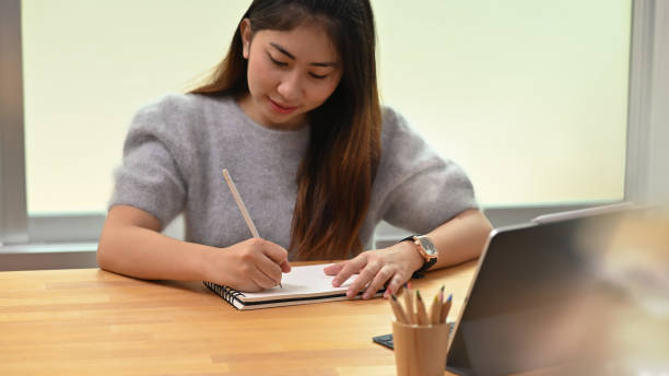 istock Woman writing her idea on notebook while working in the comfortable office room. 1172207227