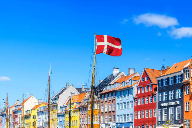 copenhagen nyhavn panorama city crowds enjoying sunshine restaurants bars denmark - danish flag imagens e fotografias de stock