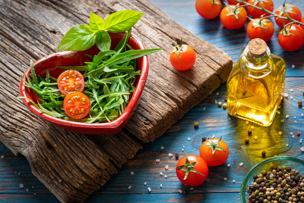 arugula salat herz form kirschtomate - cherry tomato image raw colors stock-fotos und bilder