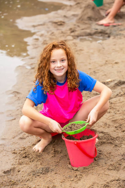 Girl Playing In Sand at Beach