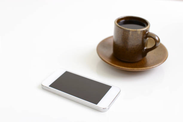 A cup of coffee and a smart phone isolated on white background
