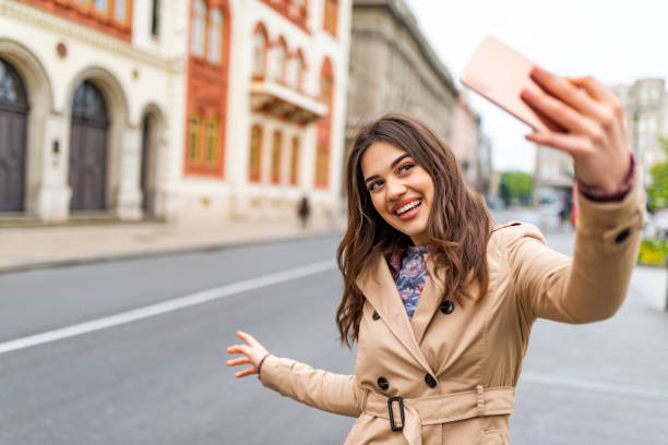 istock Lovely curly woman making selfie while walking past old building. 1172211959