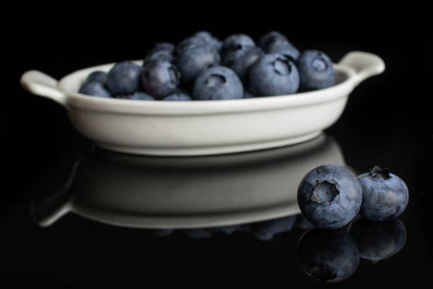 istock Fresj blue bilberry isolated on black glass 1172213201